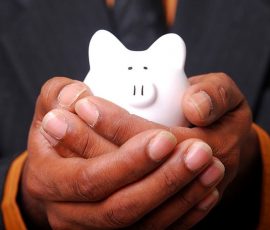 Man holding small piggy bank in his hands