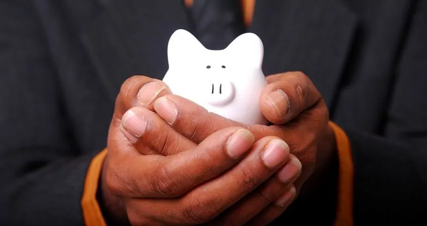 Man holding small piggy bank in his hands