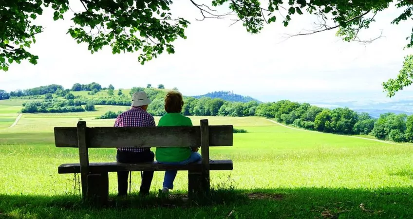 A senior couple sitting in a bench in a park