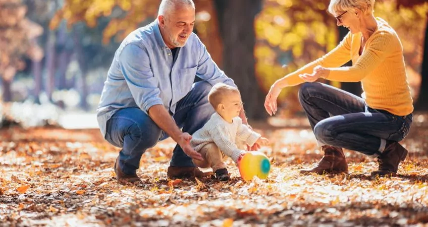 Grandparents playing outside with their grandchild