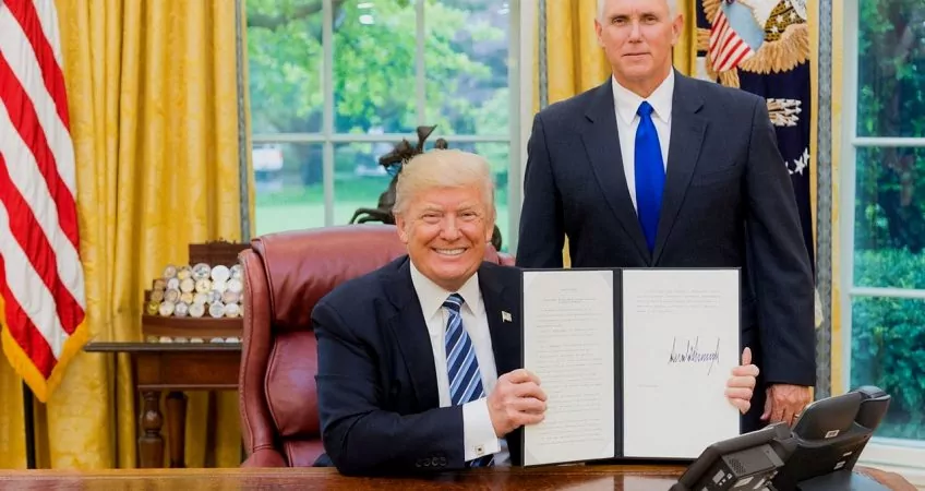 The Donald Posing with a bill which he has recently signed in the white house