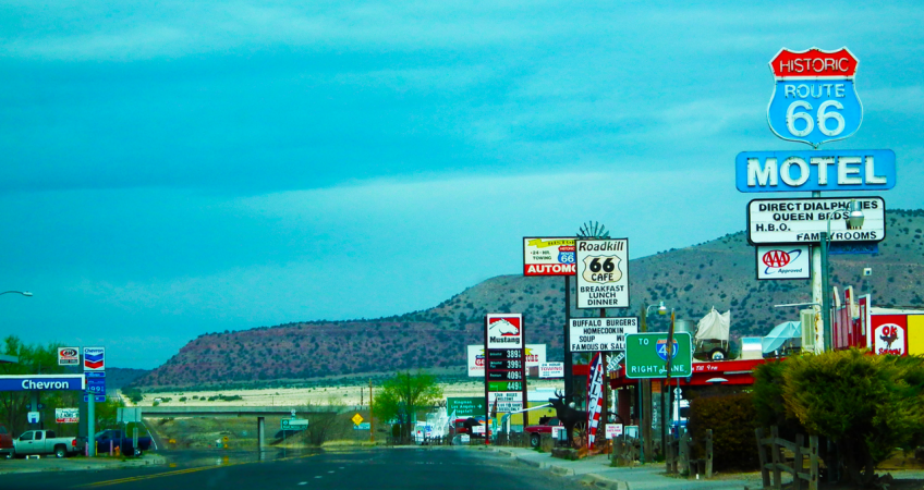 Image of a town on route 66. Neon signs in the foreground and mountains in the background