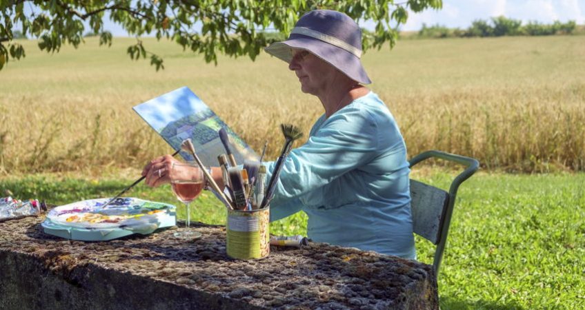 A senior artist in the countryside painting