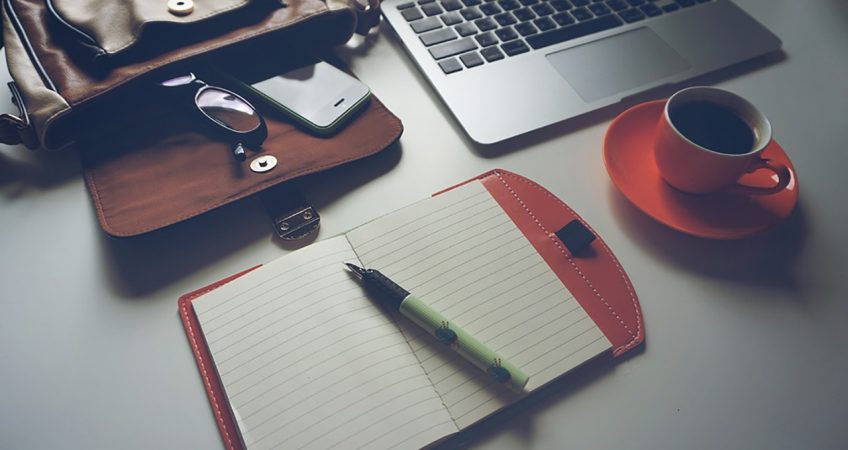 Travelling businessman's desk with coffee and work equipment