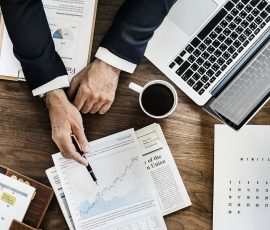 Office worker making plans with laptop and coffee