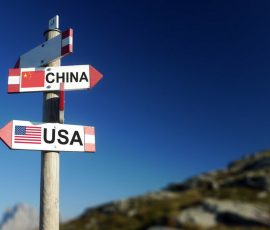 USA and Chinese flags on mountain signpost