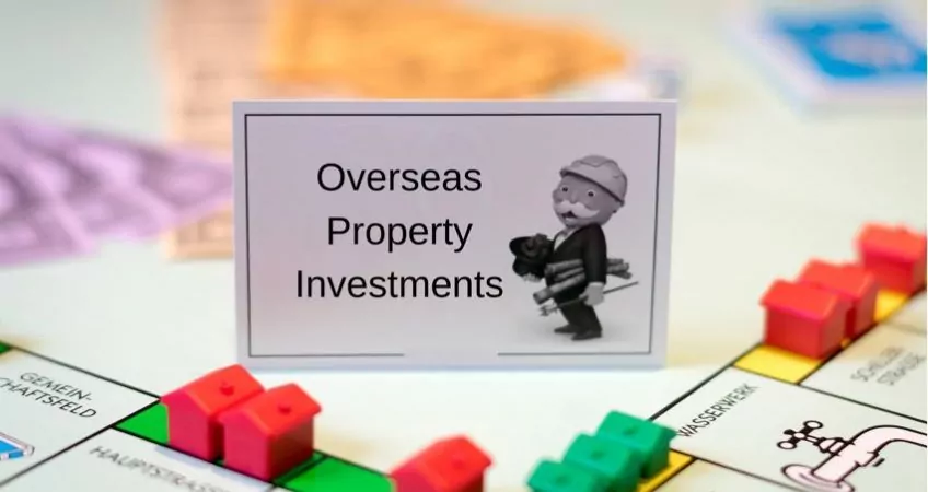 A monopoly board with houses and hotels and a card that reads "overseas property investments"