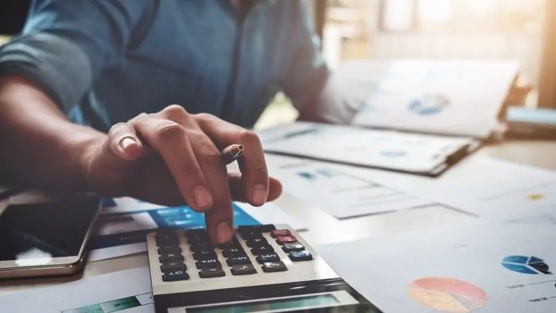 man calculating taxes with a calculator