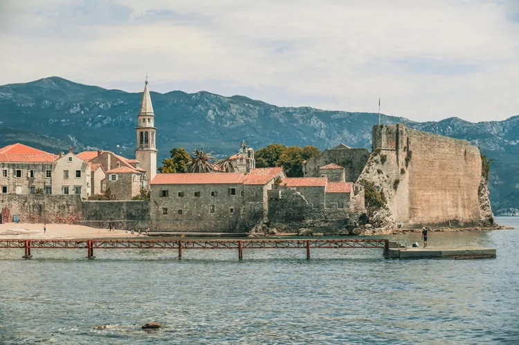 Old town of Budva with churches near ocean and mounts