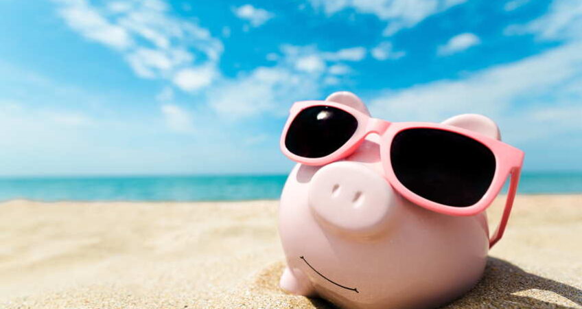 piggy bank with sunglasses on the beach