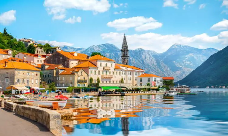 View of the Bay of Kotor with buildings and boats and mountains in the background