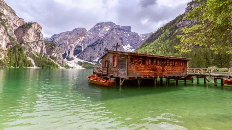 View of a boat house on the famous Lake Braies with emerald water in Italy