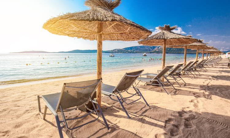 Beach chairs with a white sand on San Ciprianu beach near Porto-Vecchio in Corsica, France
