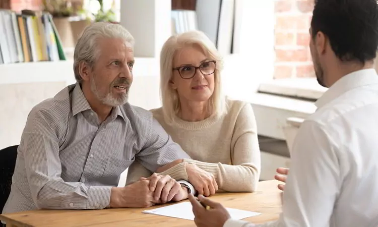 Happy mature couple meeting with financial consultant in office