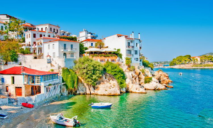 Beautiful houses next to blue waters in the island of Skiathos in Greece