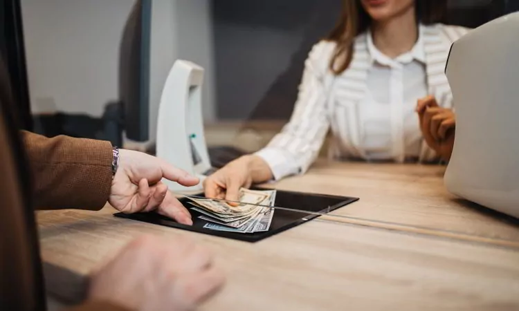 Woman giving cash money to male customer