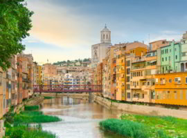 Girona colorful houses district, bridge, and Saint Mary Cathedral, buildings reflected in water in river Onyar. Catalonia Spain.