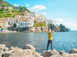 Man standing by sea looking at city view in Italy
