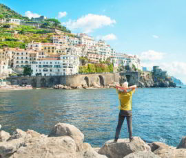 Man standing by sea looking at city view in Italy