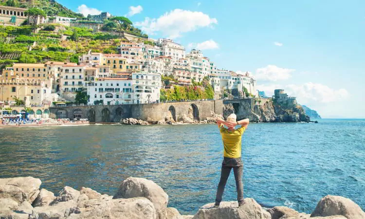 Man standing by sea looking at city view in Italy