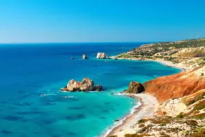 Seashore and pebble beach with wild coastline in Cyprus island, Greece by Petra tou Romiou sea rocks