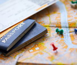 Pins marking travel itinerary points on map and passport