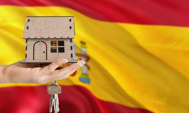 Woman hand holding wooden house and keys with hand