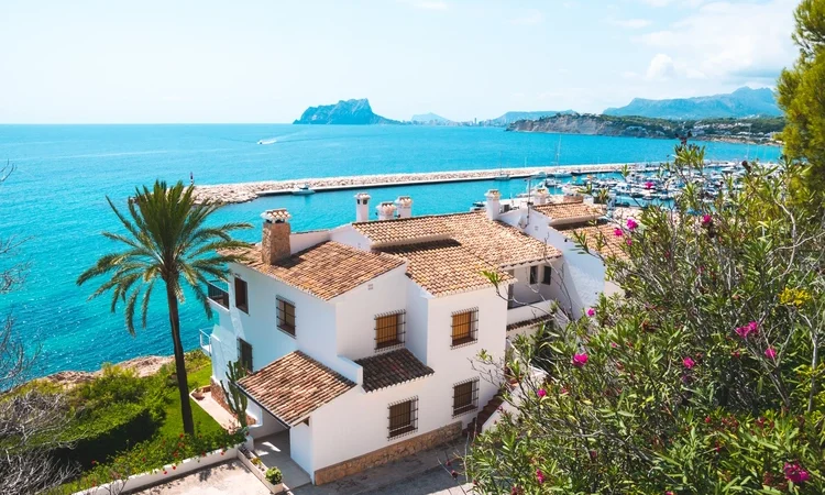 Traditional white houses with unspoilt idyllic view of marina, coastline and Mediterranean Sea in Moraira, Costa Blanca, Spain