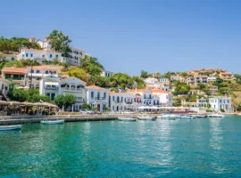 Beautiful sunny greek village town white house and harbor view to the aegean blue sea with crystal clear water and fishing boats cruising yacht white houses, Ikaria Island, Evdilos, Sporade, Greece