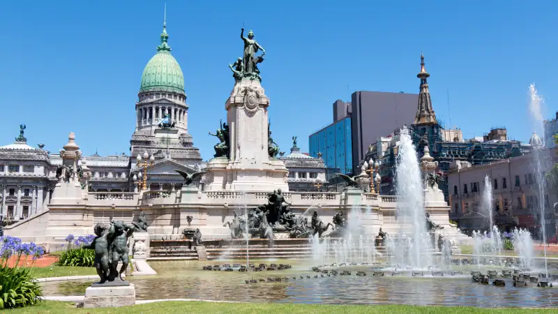 The Palace of the Argentine National Congress with fountains and statues in front, under a clear blue sky in Buenos Aires.
