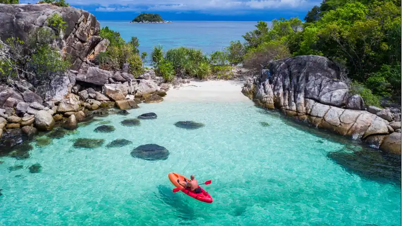 Aerial drone view of in kayak in crystal clear lagoon sea water during summer day near Koh Lipe island in Thailand. Travel tropical island holiday concept