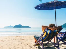 Summer lifestyle Asian man traveler relaxing on beach chair in front of vacation exotic beach, Attraction place leisure tourist travel Hua Hin Thailand holiday trip, Tourism beautiful destination Asia