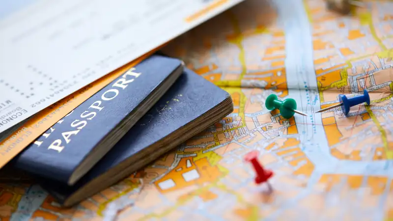 pins marking travel itinerary points on map and passport