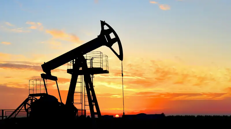 Oil drilling derricks at desert oilfield. Crude oil production from the ground. Oilfield services contractor. Oil drill rig and pump jack.